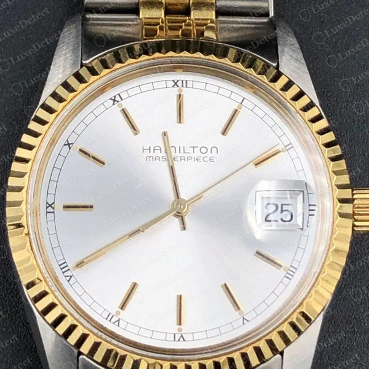 Genuine Hamilton Masterpiece watch with a silver dial reading HAMILTON MASTERPIECE, gold-coloured baton markers, a date window showing 25 and a fluted gold-coloured bezel on a two-tone bracelet
