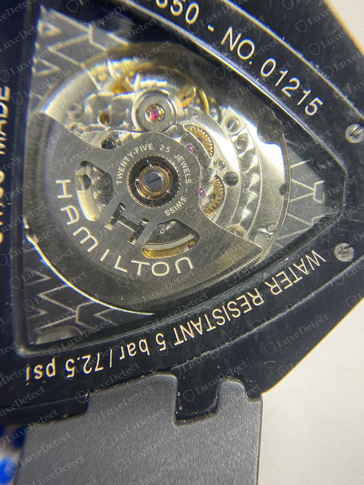 Back of a genuine black Hamilton Ventura with a display window, showing an automatic movement and a rotor marked HAMILTON and TWENTY-FIVE 25 JEWELS, with the reference and number and a water-resistance line engraved around the rim
