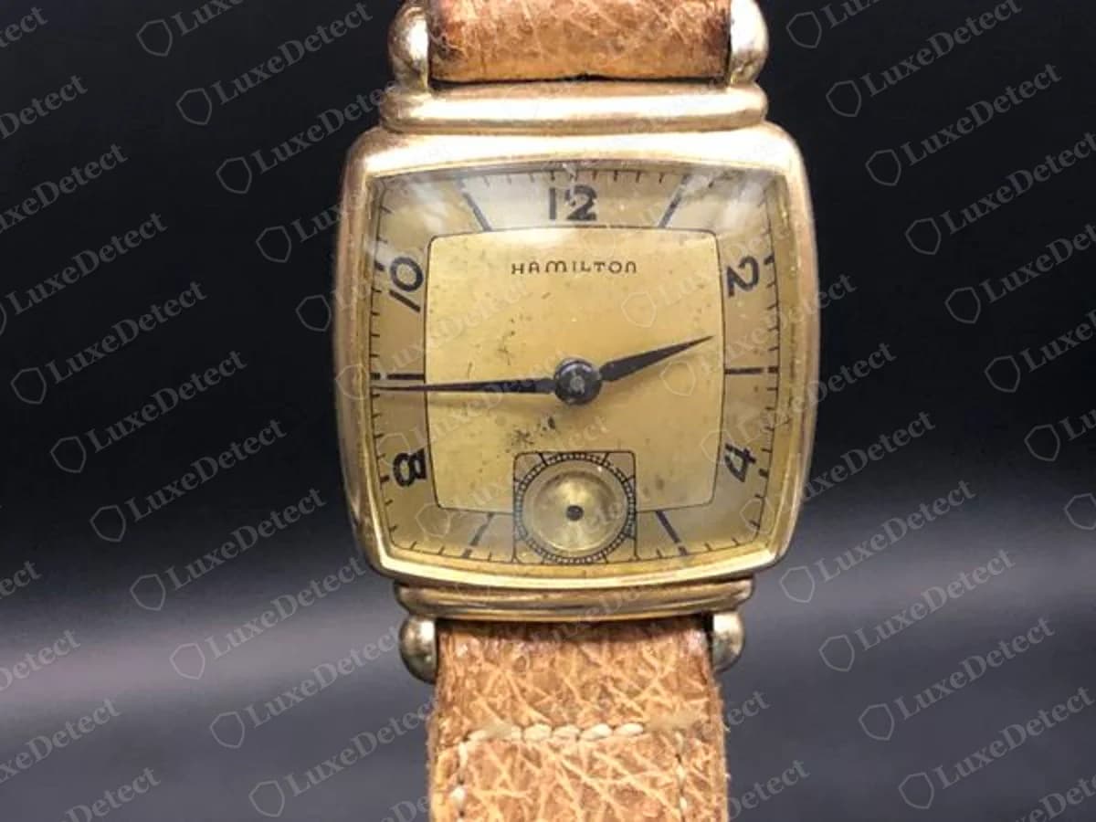 Genuine vintage Hamilton dress watch with a square gold-coloured case, HAMILTON in small capitals on a champagne dial, Arabic numerals and a small seconds dial at six o'clock, on a tan leather strap