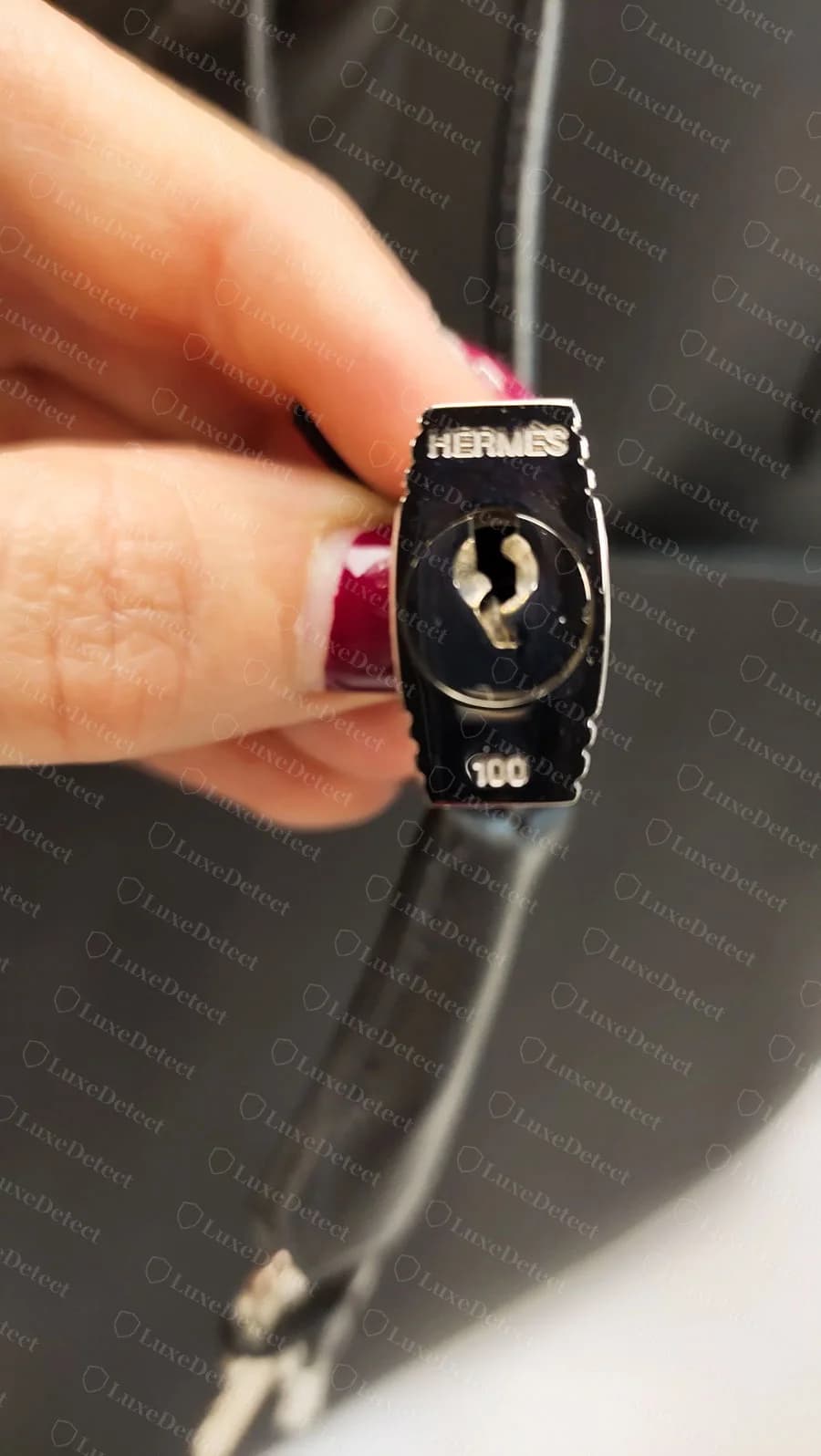 Hermès Bolide padlock stamped HERMÈS with a three-digit number ("100" here), the number that should also appear on both matching keys