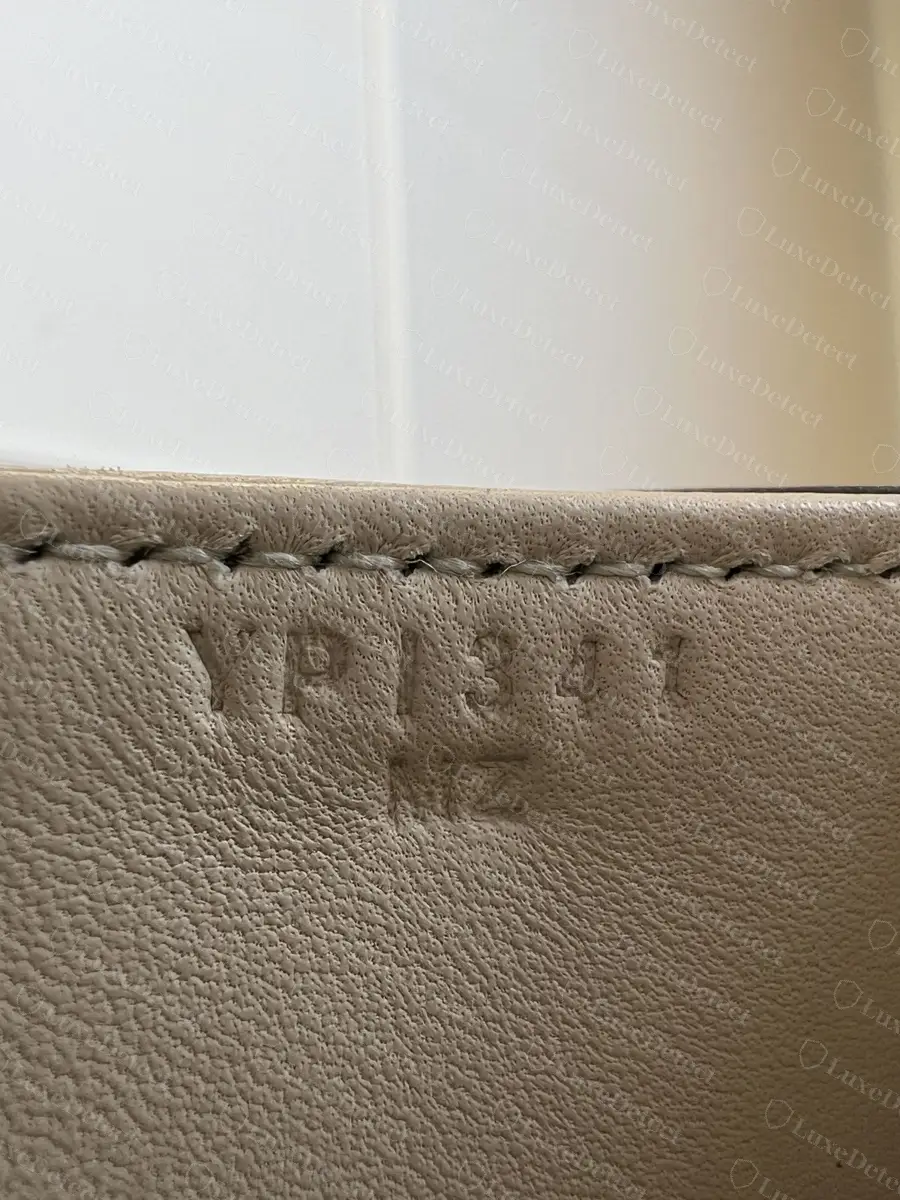 Embossed interior code on the lining leather of a genuine lizard Constance 18, six characters over a two-letter line
