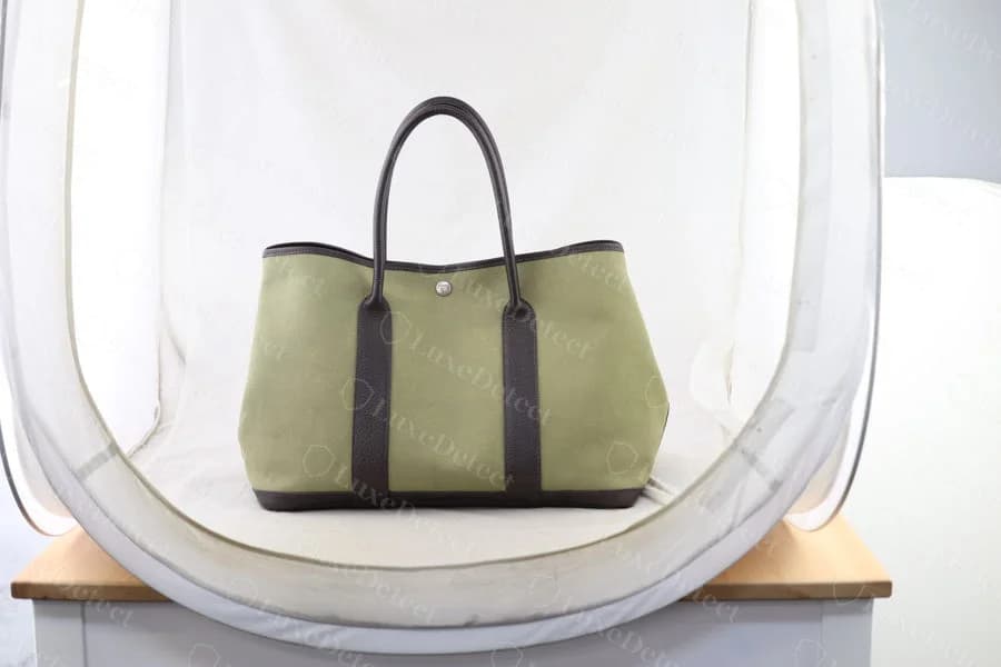 Genuine Garden Party in a canvas-and-leather colorway, olive toile canvas body with dark leather trim at the handles and base