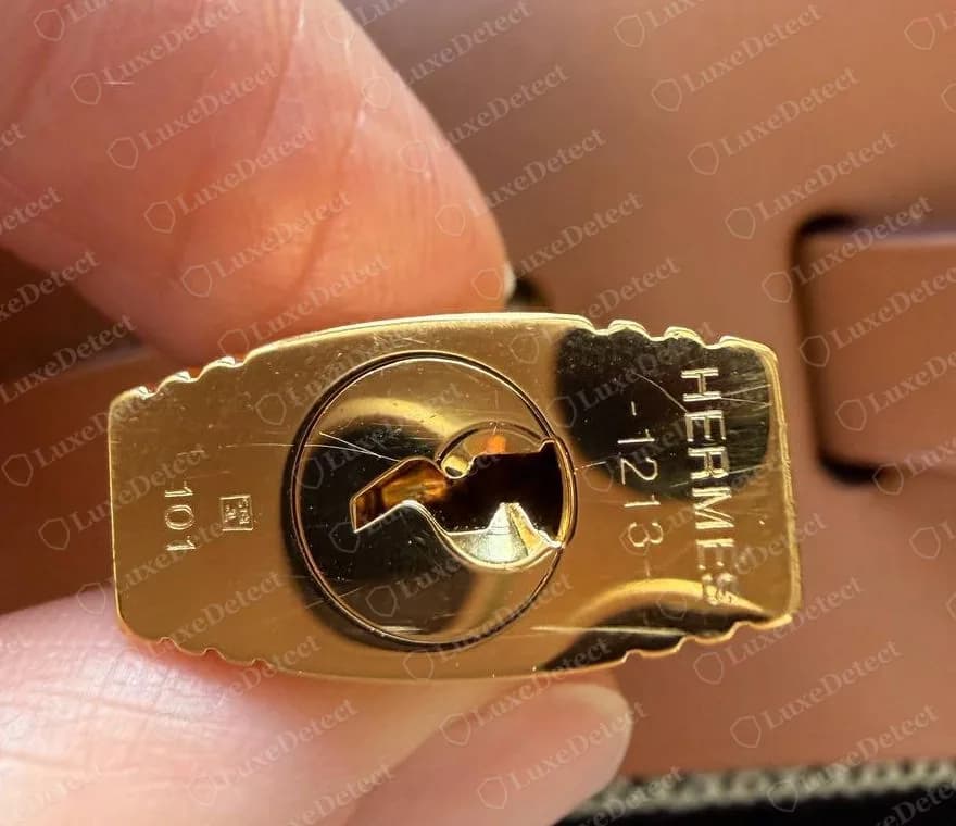 Goldfarbene Cadena einer echten Herbag Zip, HERMÈS auf einer Seite eingraviert und die Schlossnummer 101 auf der anderen