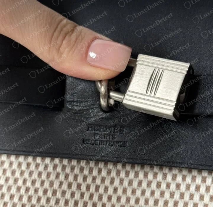 El mismo sello de tres líneas HERMÈS PARIS MADE IN FRANCE en la solapa negra de un Herbag original de 2001, bajo el candado paladio