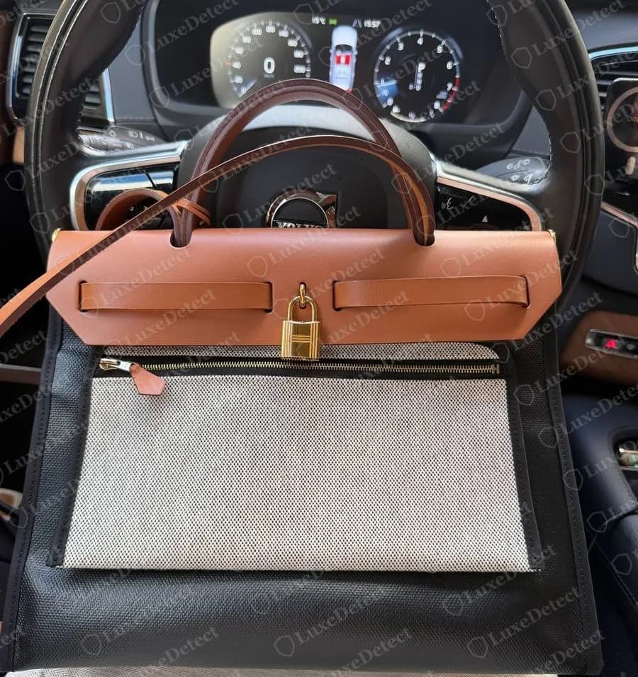 Authenticated Hermès Herbag Zip from 2024, tan Vache Hunter flap over a black canvas body, gold-tone cadena, zipped front pocket under the flap