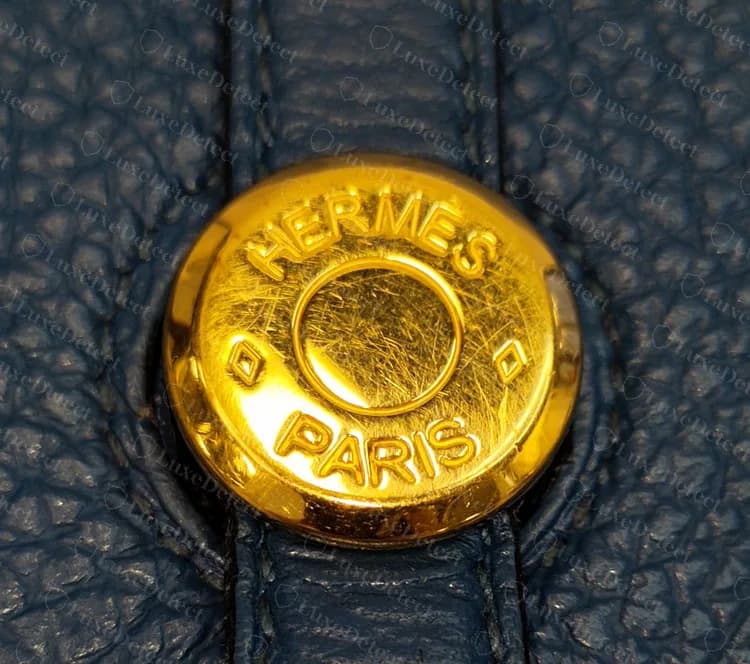 Broche dorado de una Dogon original sobre una lazada de correa azul marino, grabado alrededor del aro con un rombo a cada lado