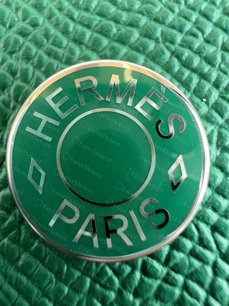 Broche de esmalte verde de un Hermesnap original, con HERMÈS PARIS grabado alrededor del aro y un rombo a cada lado