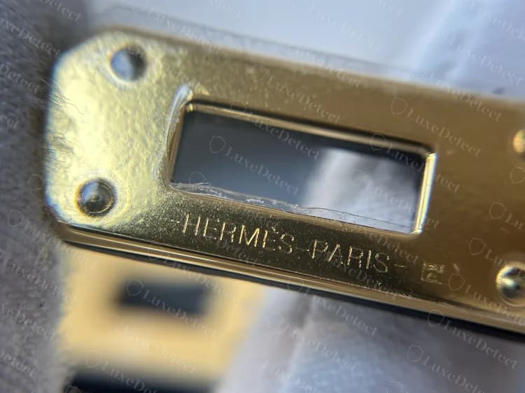 Placa del cierre de una Kelly To Go original grabada -HERMÈS-PARIS- seguida de una pequeña marca