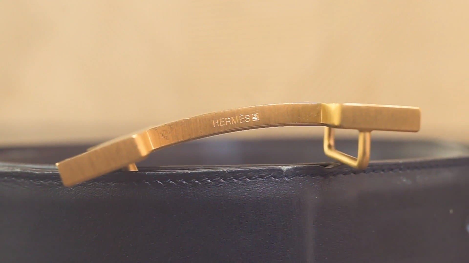 Hermès crossbar stamp — "HERMÈS" engraved on the H crossbar with plating indicator square