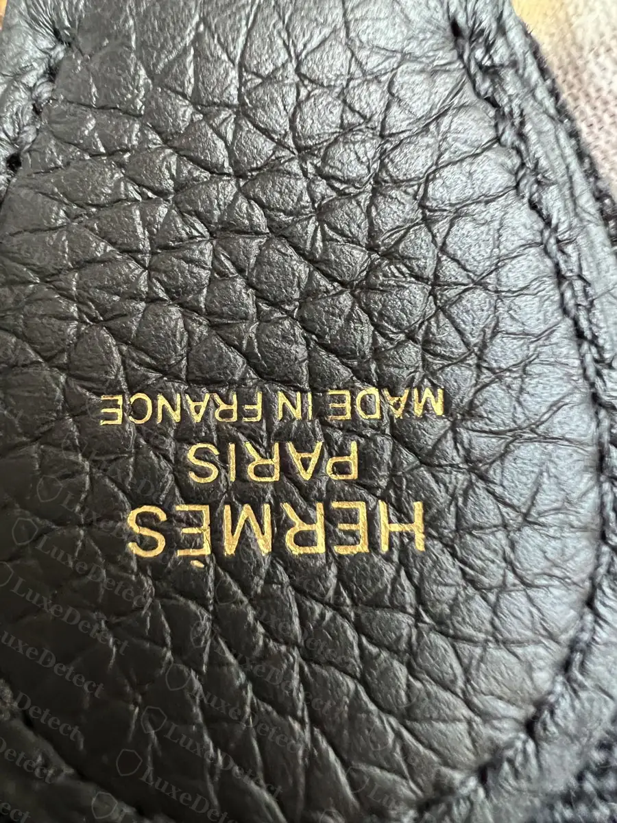 Authentic Evelyne blind stamp, gold-foil HERMÈS PARIS MADE IN FRANCE on the underside of the strap keeper tab, even serif and spacing