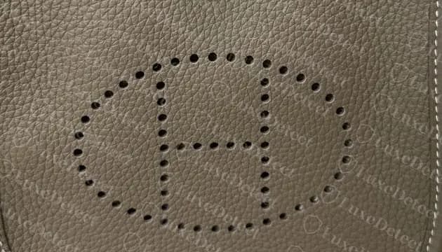 Authentic perforated H, evenly spaced holes and a crossbar centred within the oval