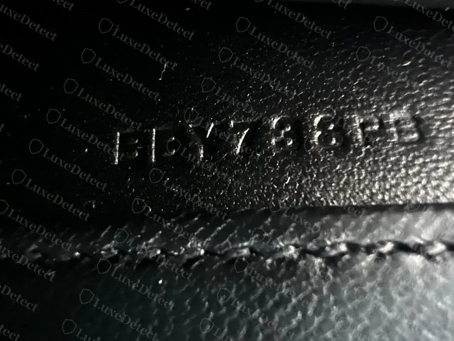Genuine Mini Kelly II interior date and craftsman stamp, blind-embossed just above a stitched seam inside the bag