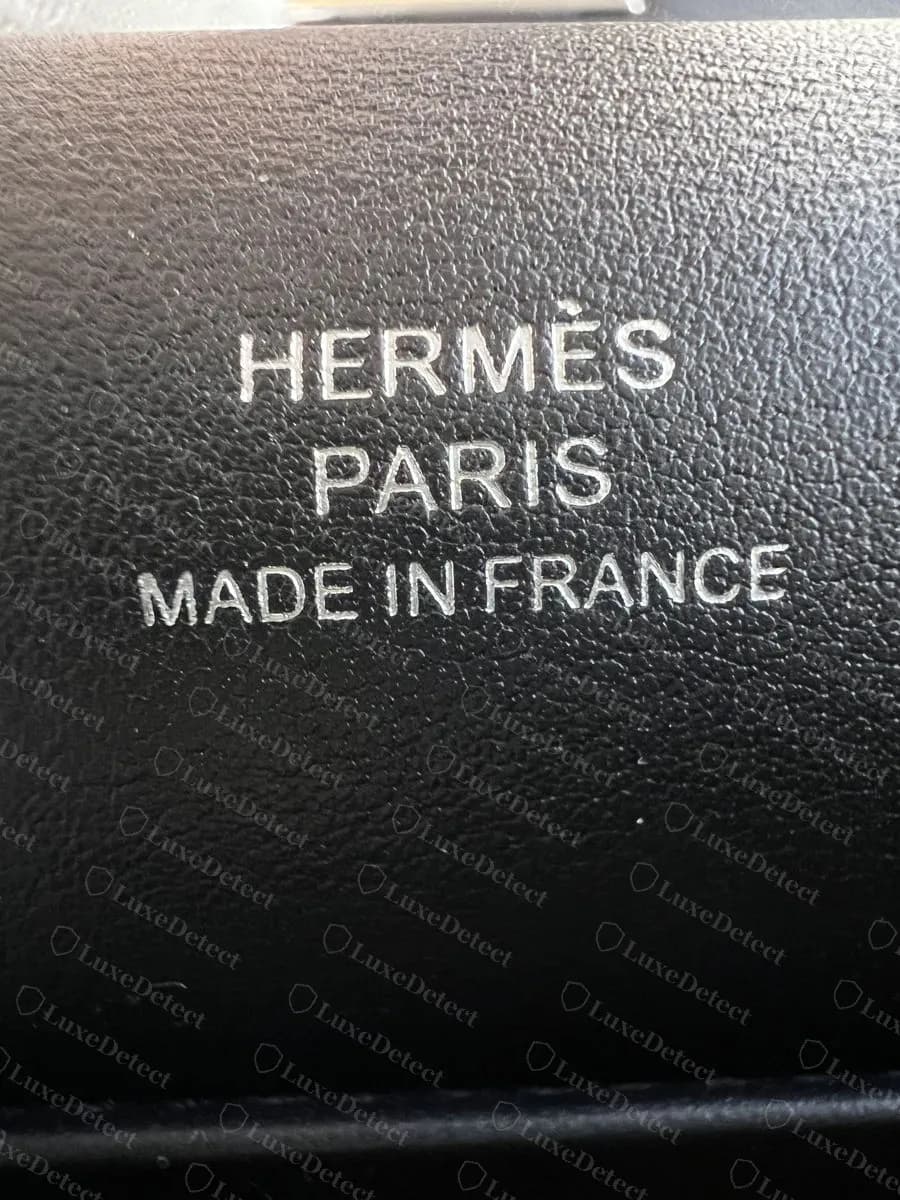Genuine Kelly Pochette interior heat stamp in silver foil on black Swift, three stacked lines, palladium-hardware bag