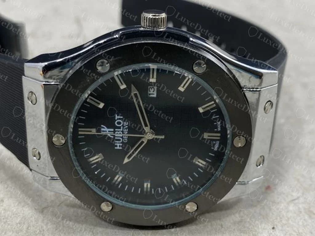 Counterfeit Hublot in the Classic Fusion style — small, soft-edged bezel screws with only a faint, shallow mark where a crisp H recess should be, around a blurry printed dial