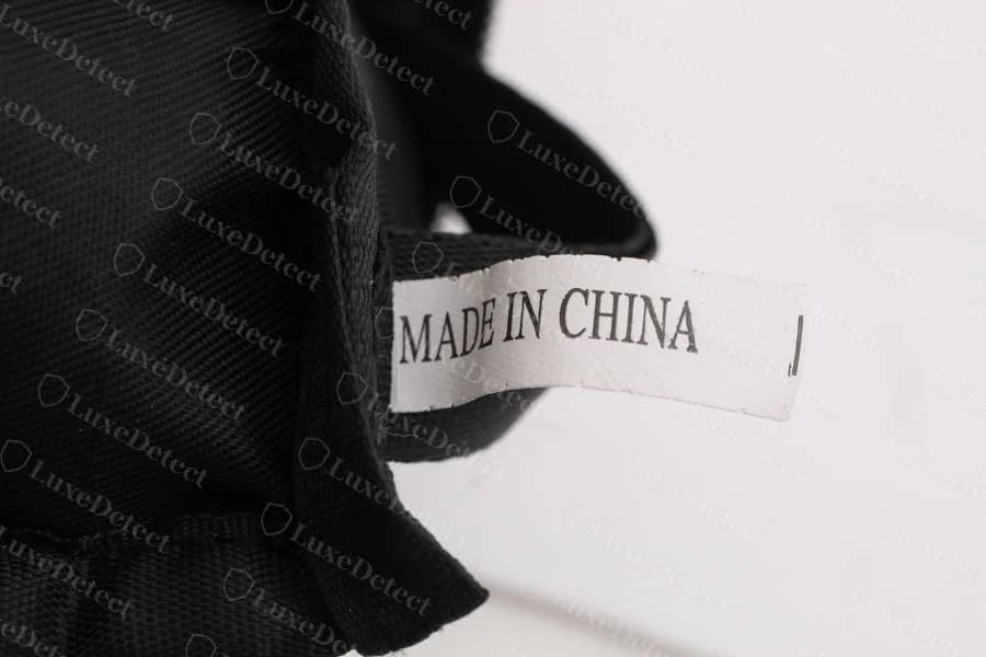 Counterfeit BAOBAO pouch — a plain white sewn tag reading "MADE IN CHINA", with no Japanese text and no style code