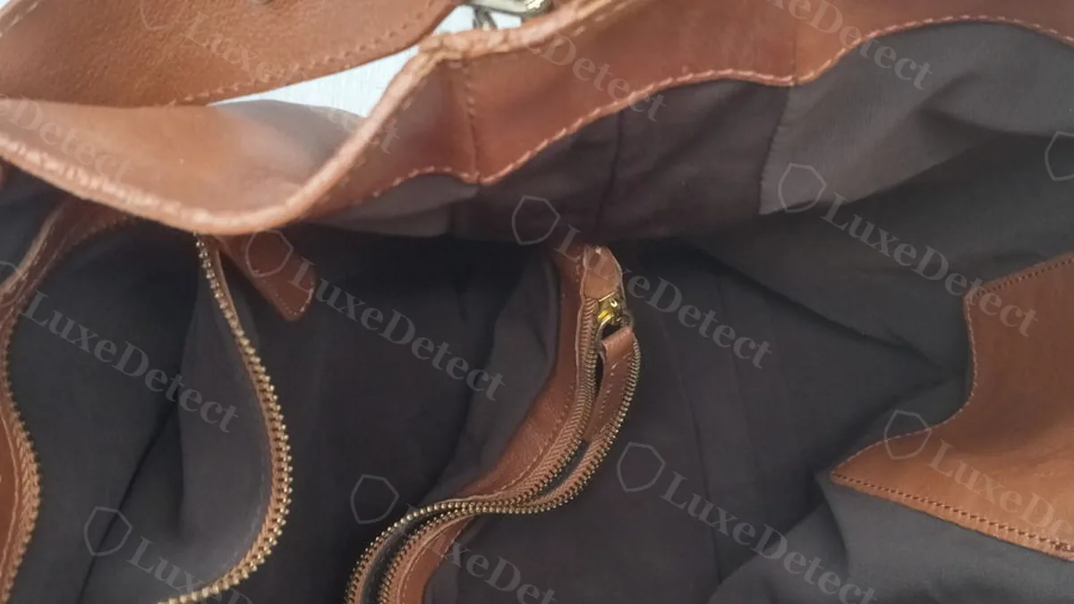 Confirmed fake Jil Sander hobo bag interior, black fabric lining with a zip pocket and a tan leather zipper pull
