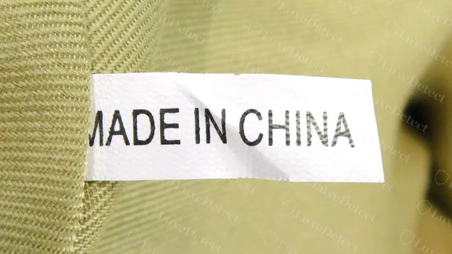 Futter einer gefälschten Tasche mit einem schlichten weißen Stoffetikett „MADE IN CHINA“, aufgenäht auf grünem Stofffutter