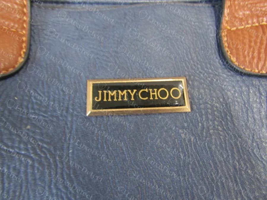 Sac bleu contrefait avec la même plaque en émail noir brillant, les lettres de JIMMYCHOO serrées les unes contre les autres