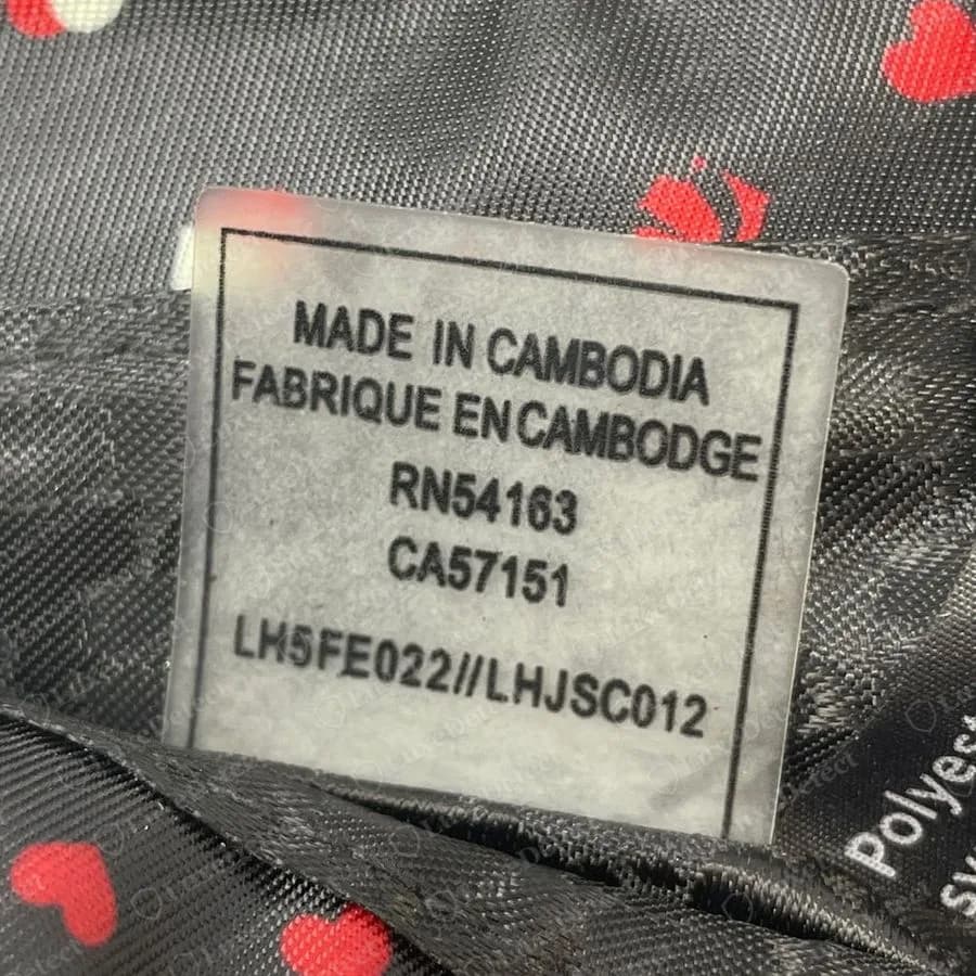 Genuine Karl Lagerfeld white bilingual care label reading MADE IN CAMBODIA, FABRIQUE EN CAMBODGE, RN54163, CA57151 and the code LH5FE022//LHJSC012, sewn inside a heart-print lining