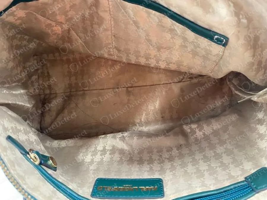 Genuine Karl Lagerfeld bag interior lined in tan jacquard with a tone-on-tone houndstooth-style pattern, and a teal leather brand plate at the bottom edge