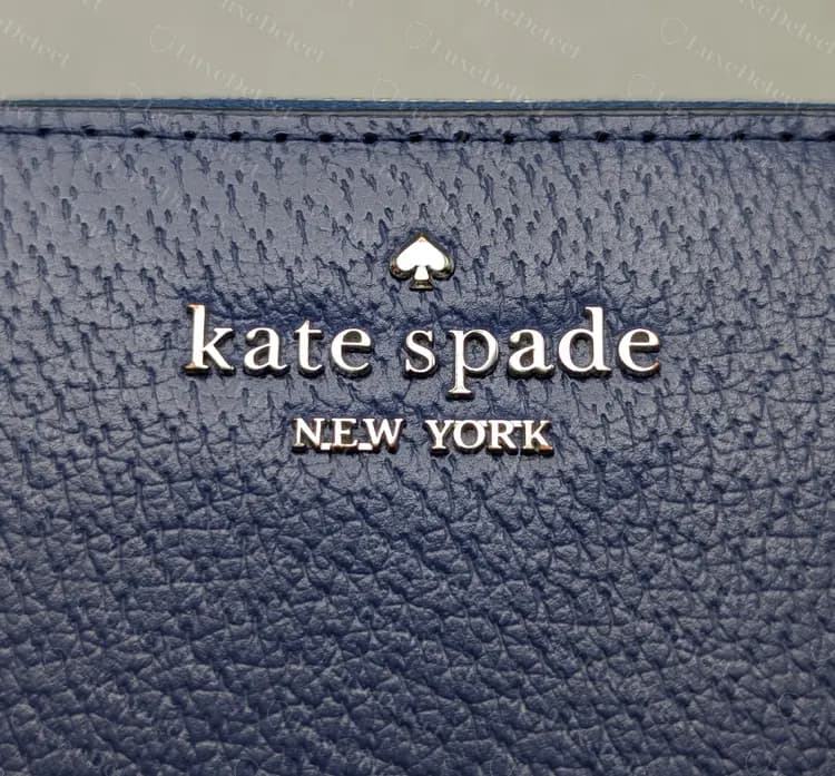 Genuine Kate Spade wallet with raised metal letters, a small spade above "kate spade" and "NEW YORK" below, set directly into grained navy leather