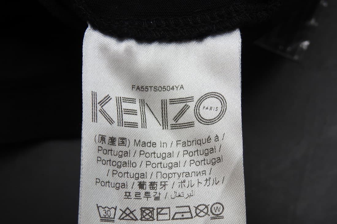 Genuine Kenzo care tag — "Made In / Portugal" printed in multiple languages beneath the KENZO wordmark, with a style code and wash symbols