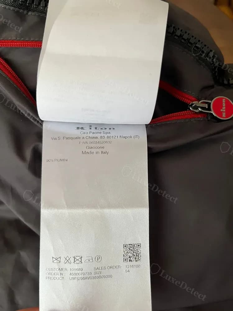 Kiton order tag showing customer number, sales order number, size, and fabric code, stitched beside the composition label
