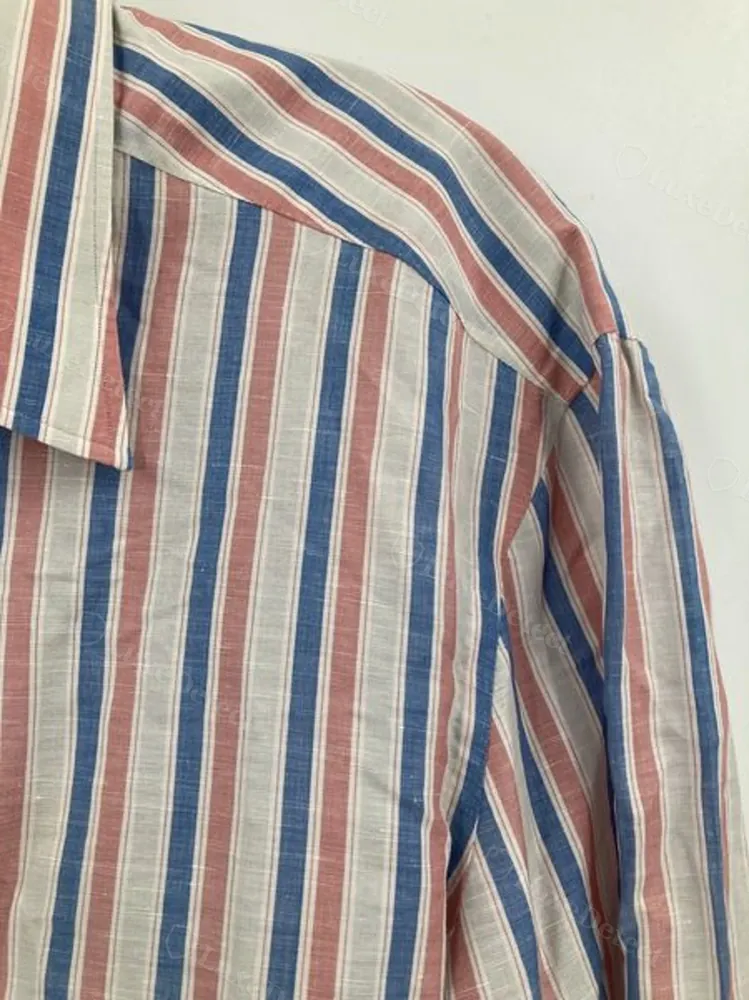 Woven Kiton neck label on a striped dress shirt, red dot over the "i", sewn into the back yoke