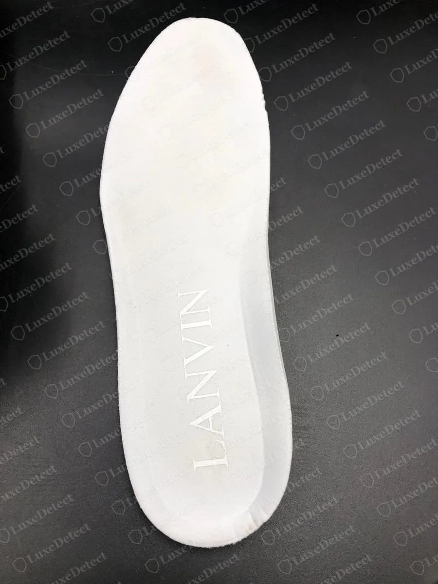 Genuine Lanvin Curb insole removed and photographed from above, a smooth plain white insole with LANVIN embossed near the heel