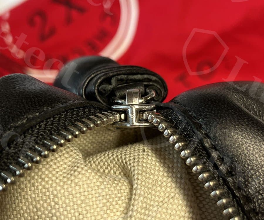 Doblez de la correa de un bolso Lemaire Croissant original en la argolla del tirador del cierre: rollo de piel bien acabado, sin soporte expuesto