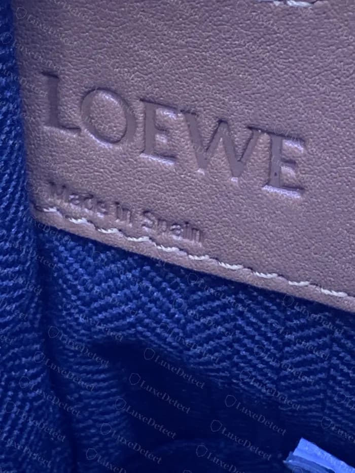 Interior de un Loewe Hammock genuino: LOEWE y Made in Spain en relieve en un parche de piel sobre el forro de espiga