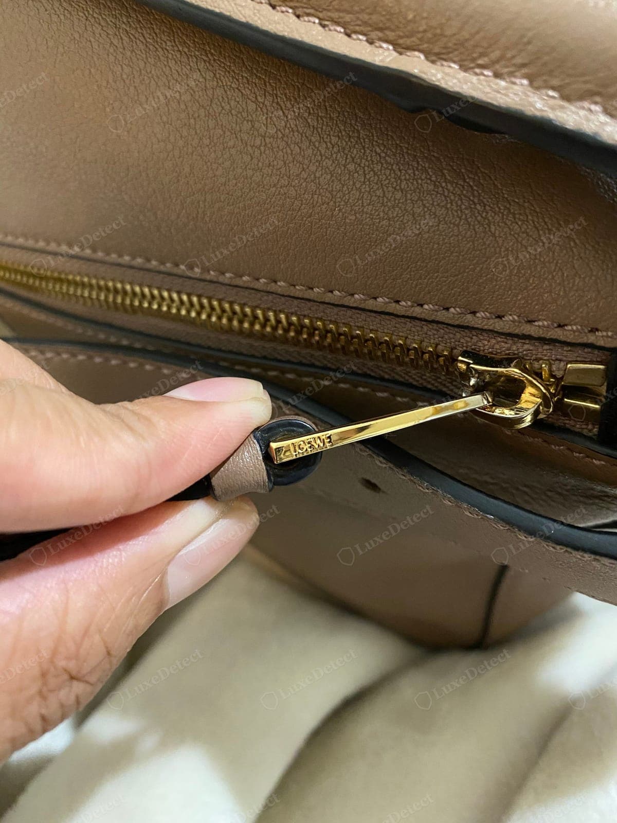 Genuine Loewe Puzzle zip-stopper engraving — "LOEWE" cut cleanly into the metal stopper at the end of the zip track