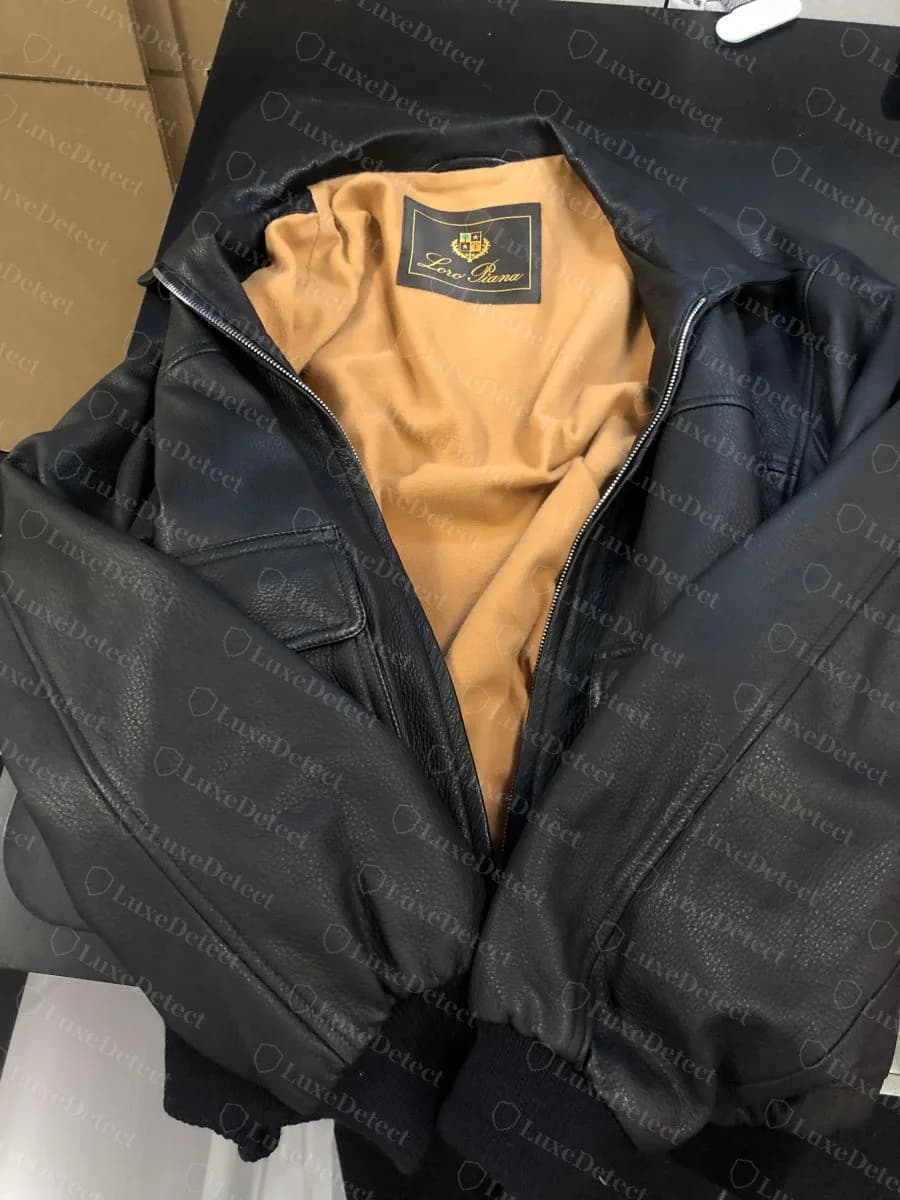 Echtes marineblaues gewebtes Wappenetikett von Loro Piana mit goldener Schrift im Inneren einer schwarzen Lederbomberjacke