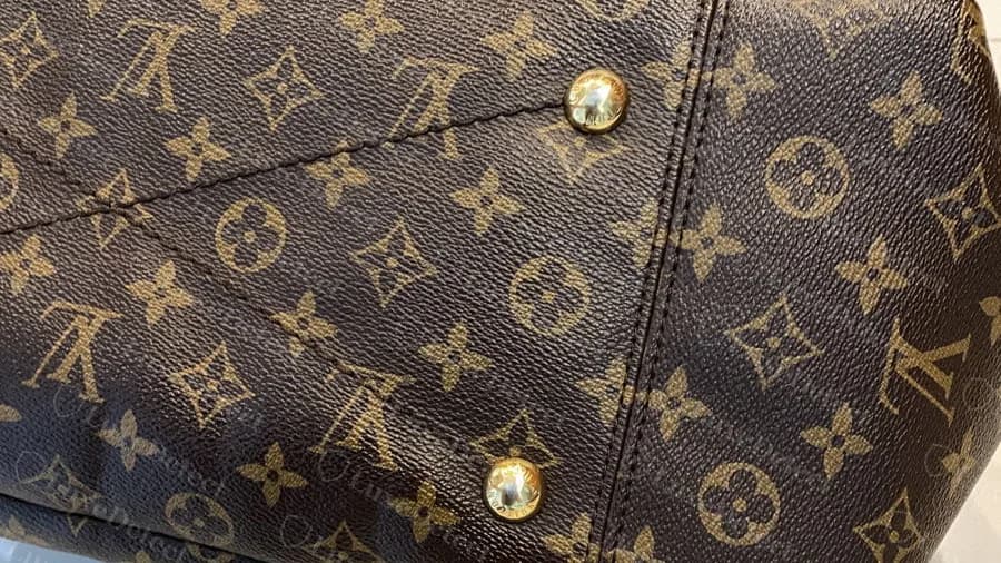 Genuine Artsy bottom panel: two domed studs on the X-shaped seam, with the Monogram pattern running across the stitching