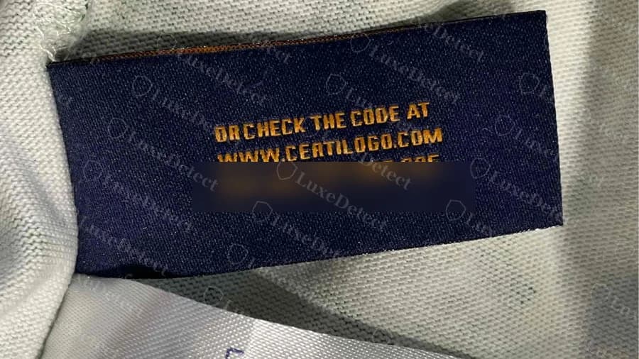 Counterfeit Louis Vuitton tee neck label reading OR CHECK THE CODE AT WWW.CERTILOGO.COM, with the code line blurred