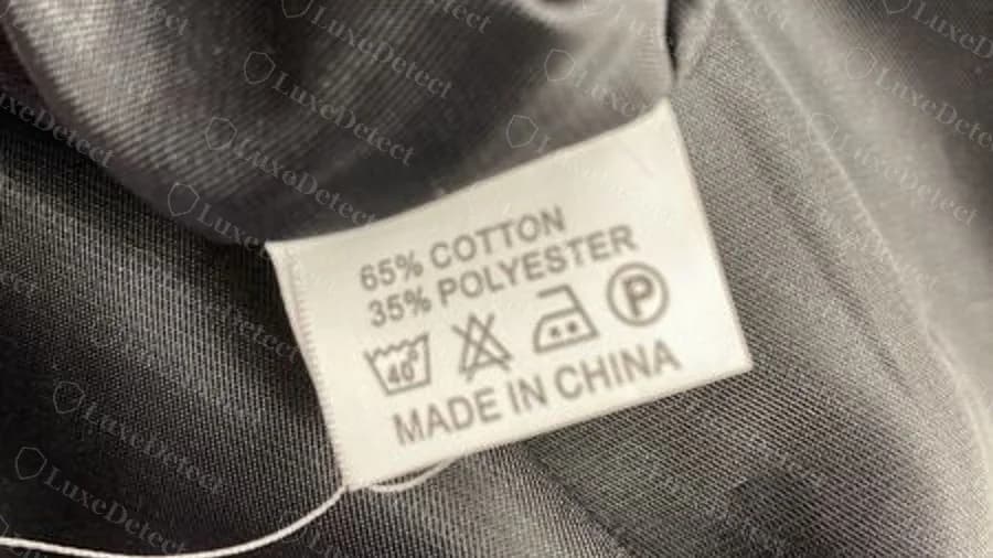 Giacca contraffatta con un’etichetta di manutenzione grigia generica con la scritta 65% cotton 35% polyester e MADE IN CHINA