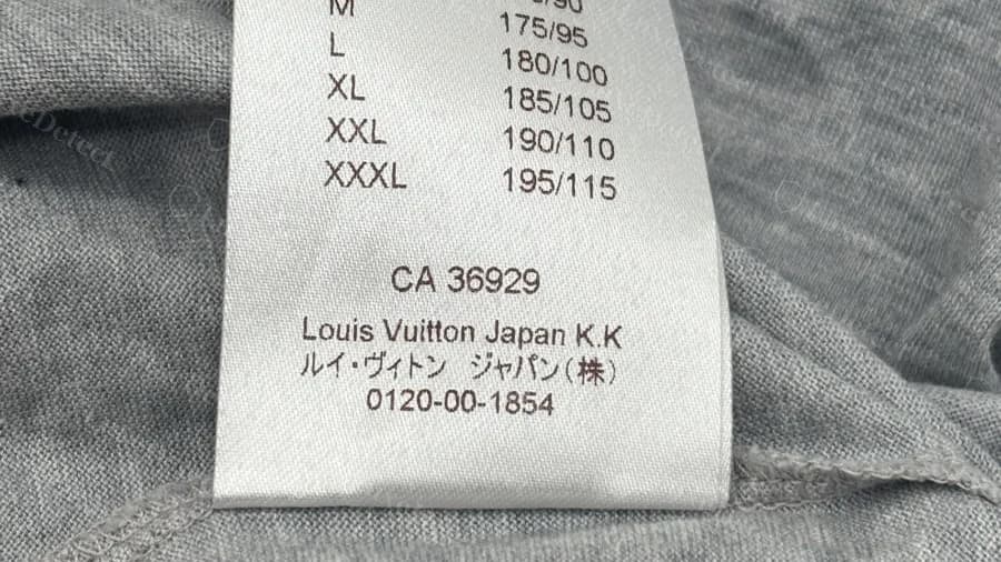 Etiqueta de la tabla de tallas de una camiseta gris Louis Vuitton falsa que imprime Louis Vuitton Japan K.K en mayúsculas y minúsculas, sin punto final