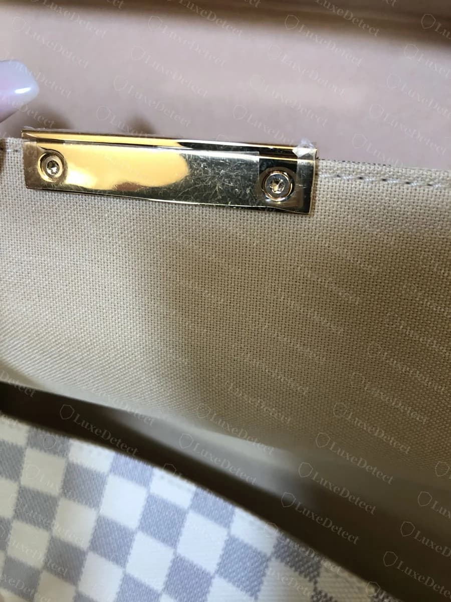 Genuine Louis Vuitton Favorite hardware interior on Damier Azur canvas, gold-tone plaque against the white and pale blue checkerboard, cream leather trim