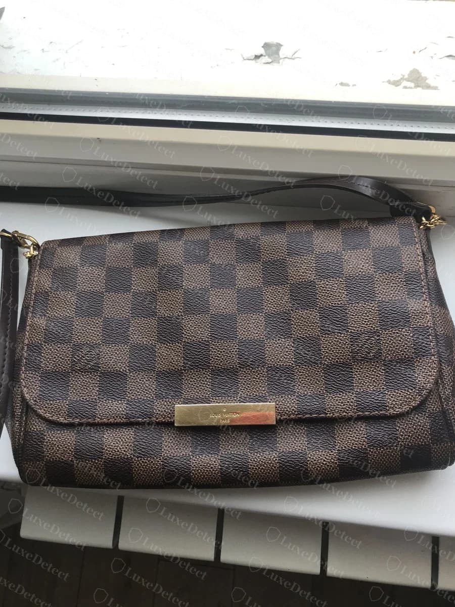 Genuine Louis Vuitton Favorite in Damier Ebene canvas, gold plaque on the flap, dark leather trim matching the checkerboard's brown and black squares