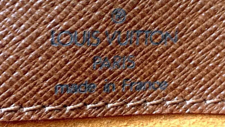 Genuine Monogram Musette Tango: flap stamp reading LOUIS VUITTON PARIS made in France, above the stitched edge of the suede lining