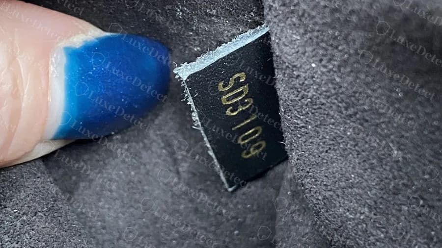 Genuine Neonoe date code SD3109 stamped in gold on a black tab with a pale cut edge