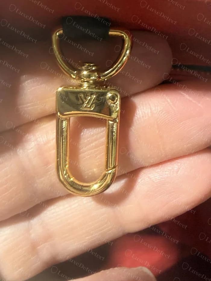Swivel clasp on a confirmed counterfeit OnTheGo in our archive, with a softer, slightly off-center LV stamp and no visible rivet detail