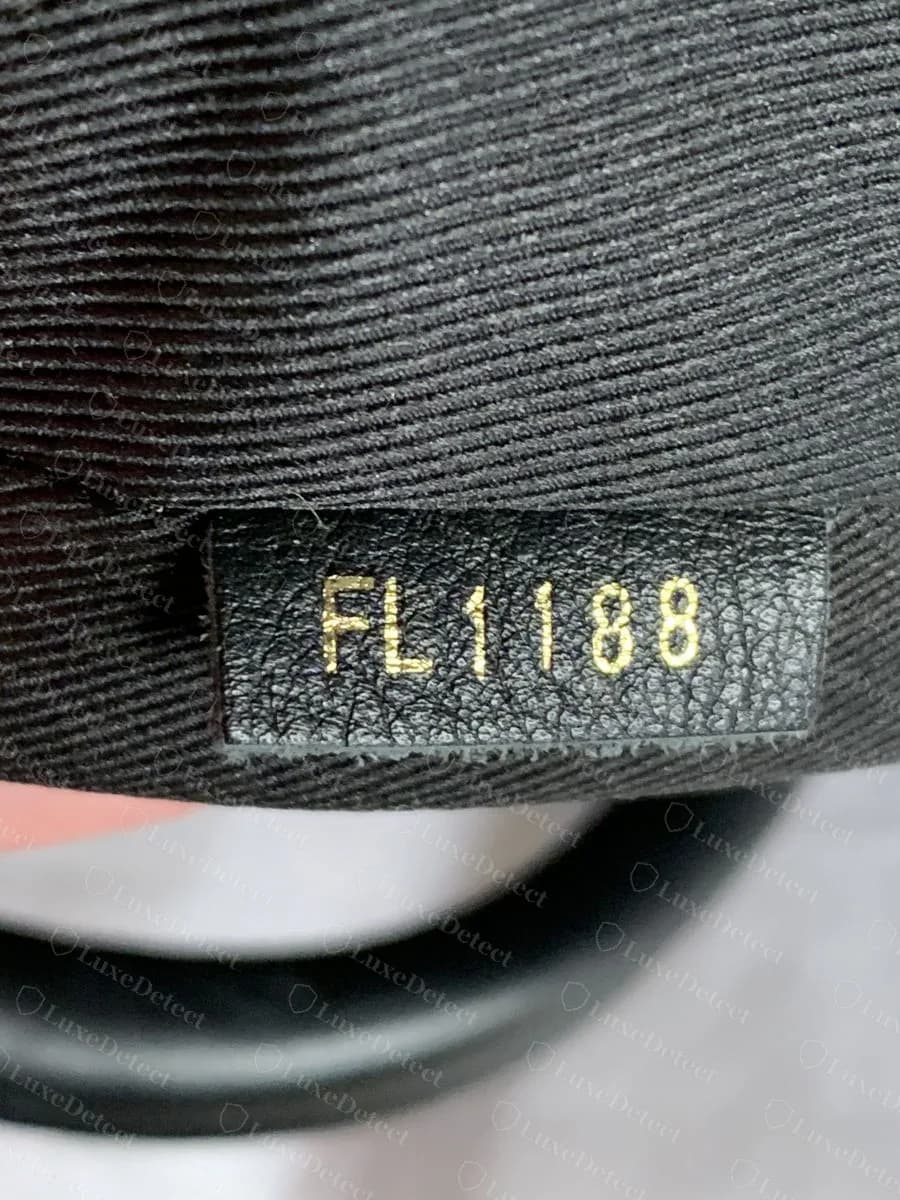 Genuine Palm Springs date code tab reading FL1188, stamped in gold on a black leather tab against the twill lining, decoding to week 18 of 2018