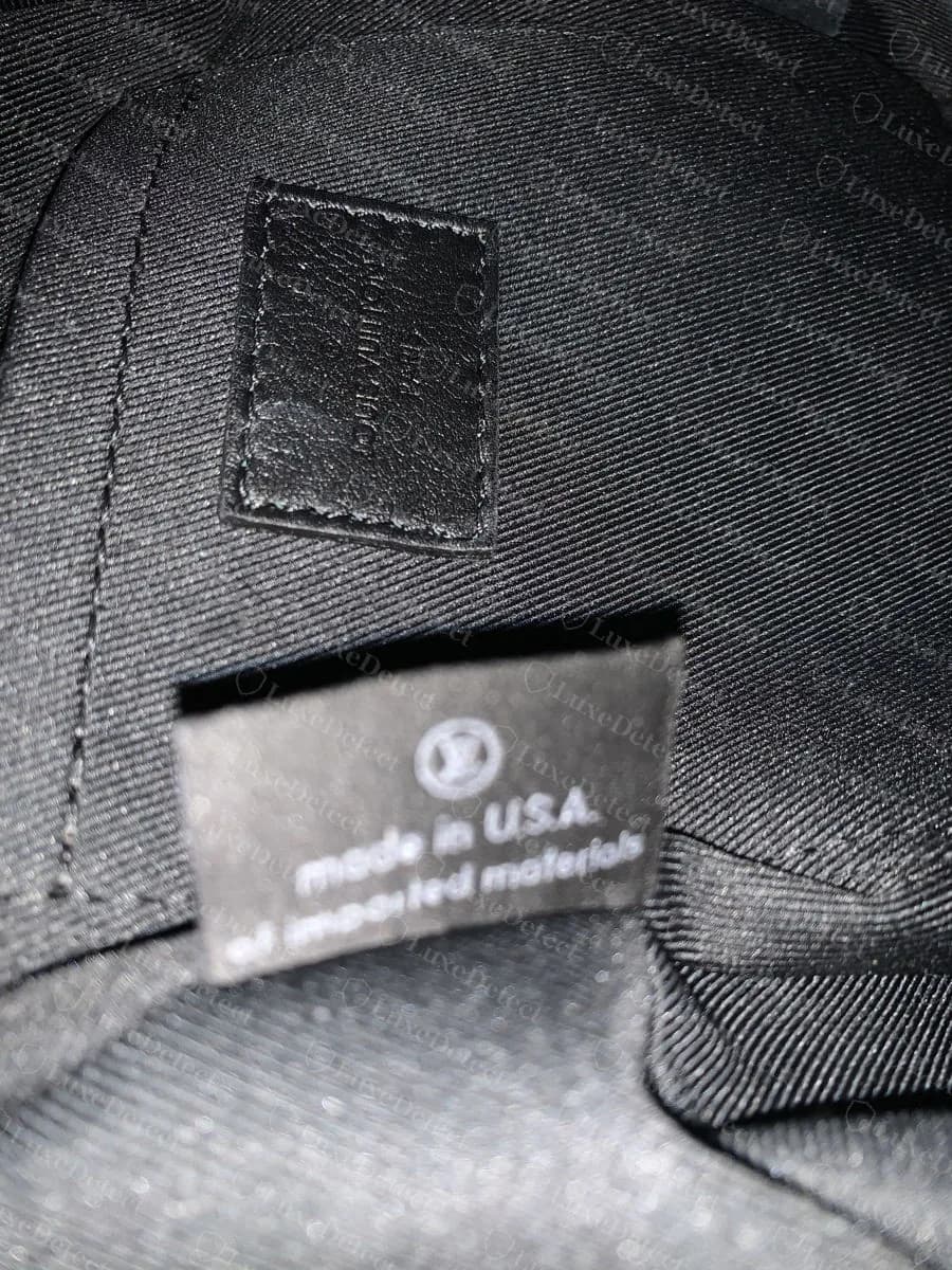 Genuine Palm Springs Reverse Mini interior: matte black lining with a visible diagonal twill weave, the leather heat-stamp patch, and a separate made in U.S.A. of imported materials label