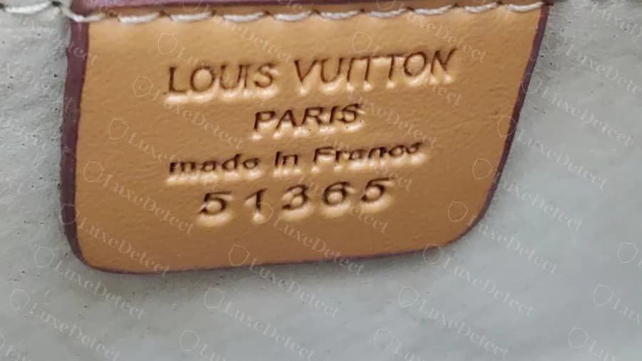 Papillon falso: una etiqueta de piel cosida con LOUIS VUITTON PARIS made in France en relieve y el número 51365