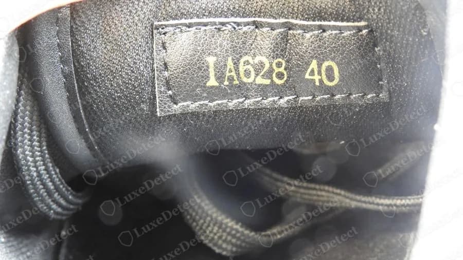 Counterfeit Louis Vuitton stamp on a gold-on-black tag reading IA628 40, letters followed by only three digits