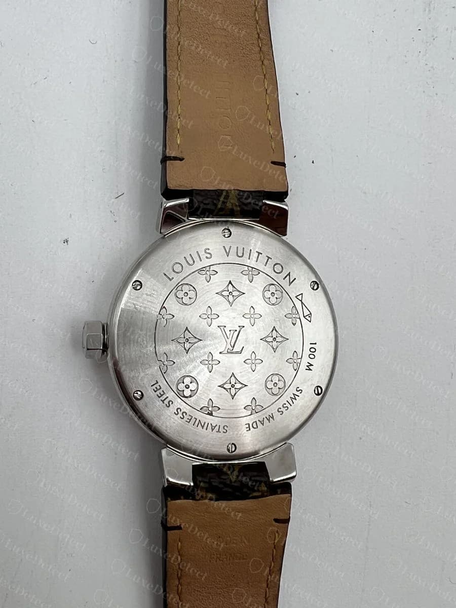 Authentic Louis Vuitton Tambour caseback: "LOUIS VUITTON / STAINLESS STEEL / SWISS MADE / 100M" around a clean monogram-flower medallion, no extra wording anywhere in the ring text