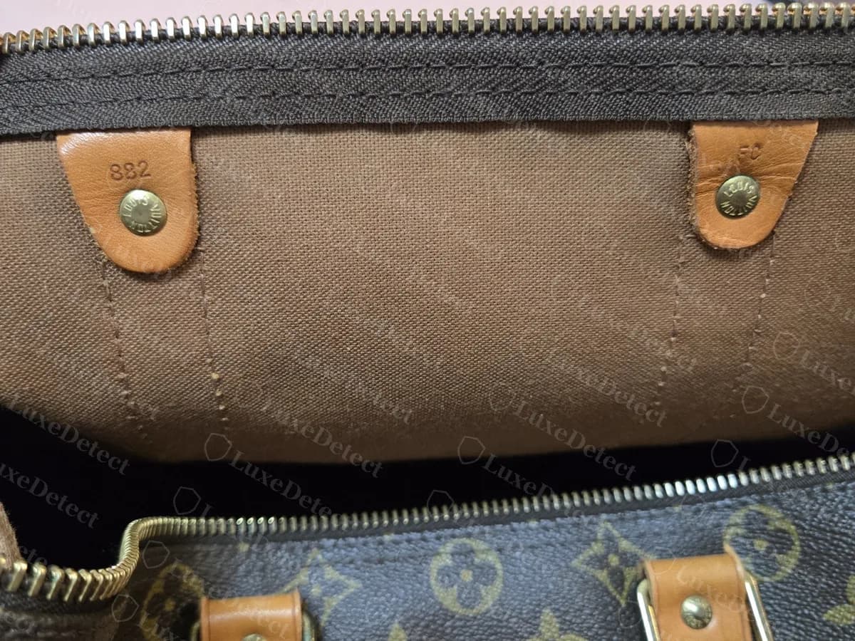 Zwei Lederlaschen im Inneren einer Monogram-Tasche: Die linke Lasche ist mit 882 gestempelt, was als Februar 1988 zu lesen ist; die rechte trägt eine kürzere Markierung, die wir nicht lesen konnten