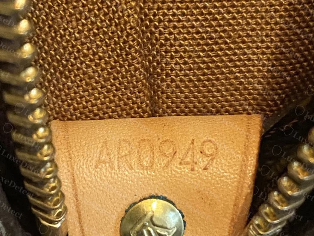 Genuine date-code tab on a Cabas Mezza: AR0949 stamped beside a rivet, month 04 and year 99, so April 1999