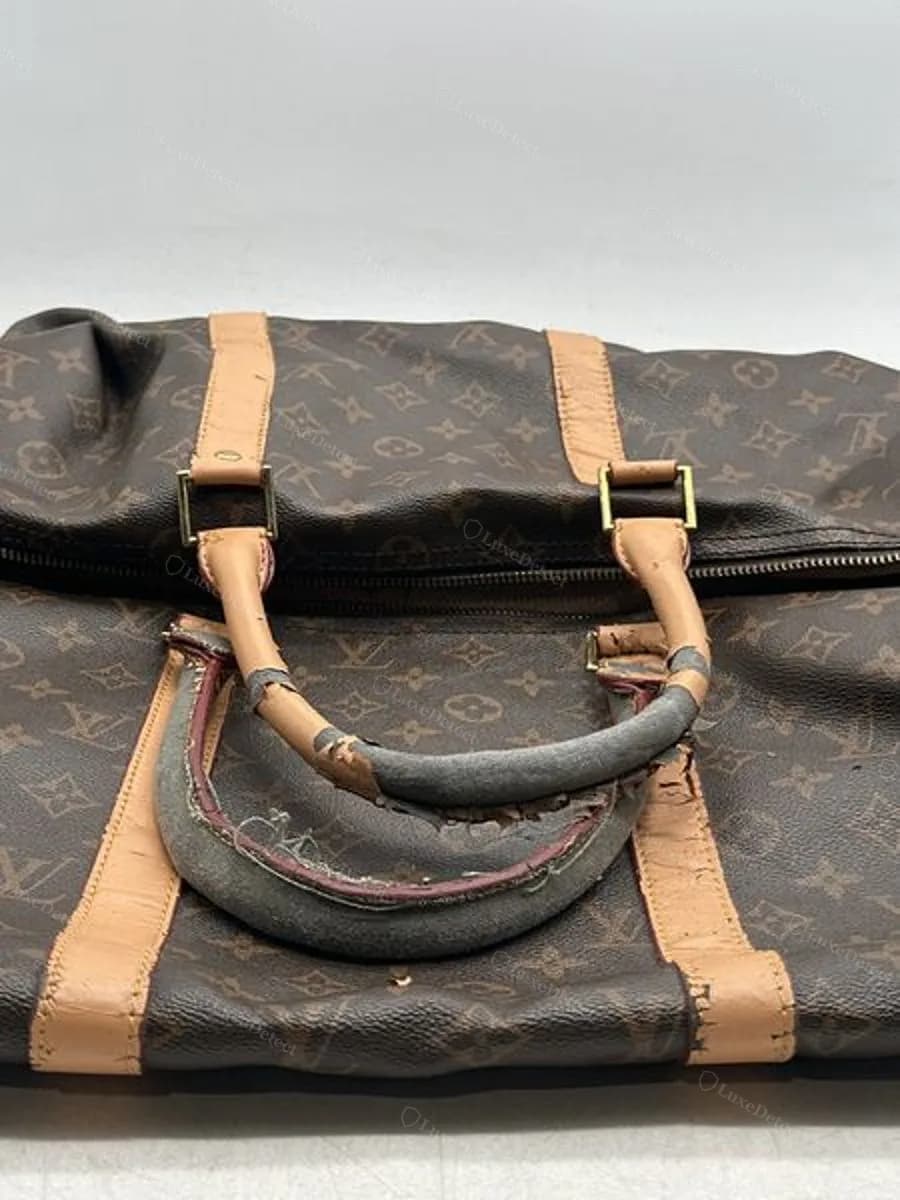 Handle covering split and peeling on a counterfeit Keepall in our archive, exposing the core material underneath — a construction-quality tell, most useful alongside the leather and stamp checks above